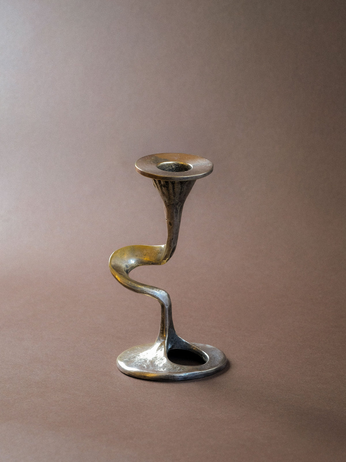 Kurt Jesch candleholder with silver-toned S-curve body, oval opening and age-related rubbing to the plated surface.