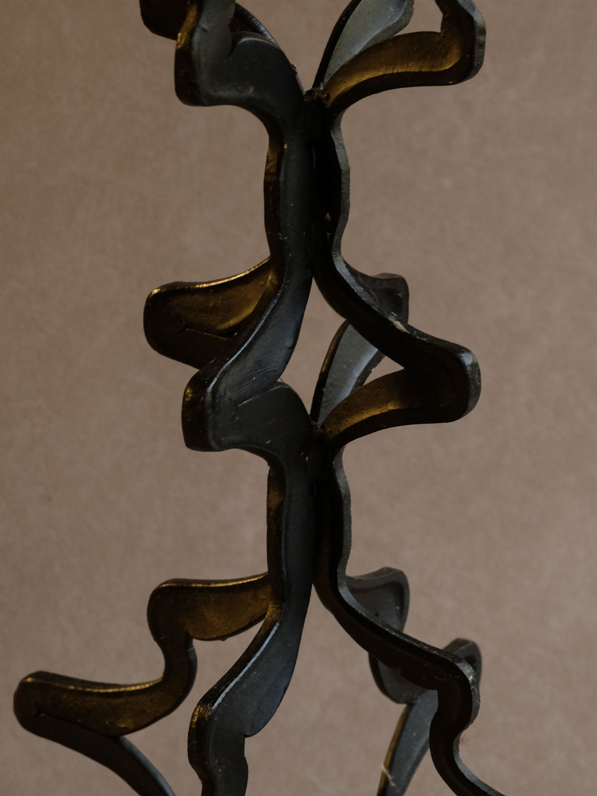 Wide weighted base of the tall sculptural vintage iron candleholder.