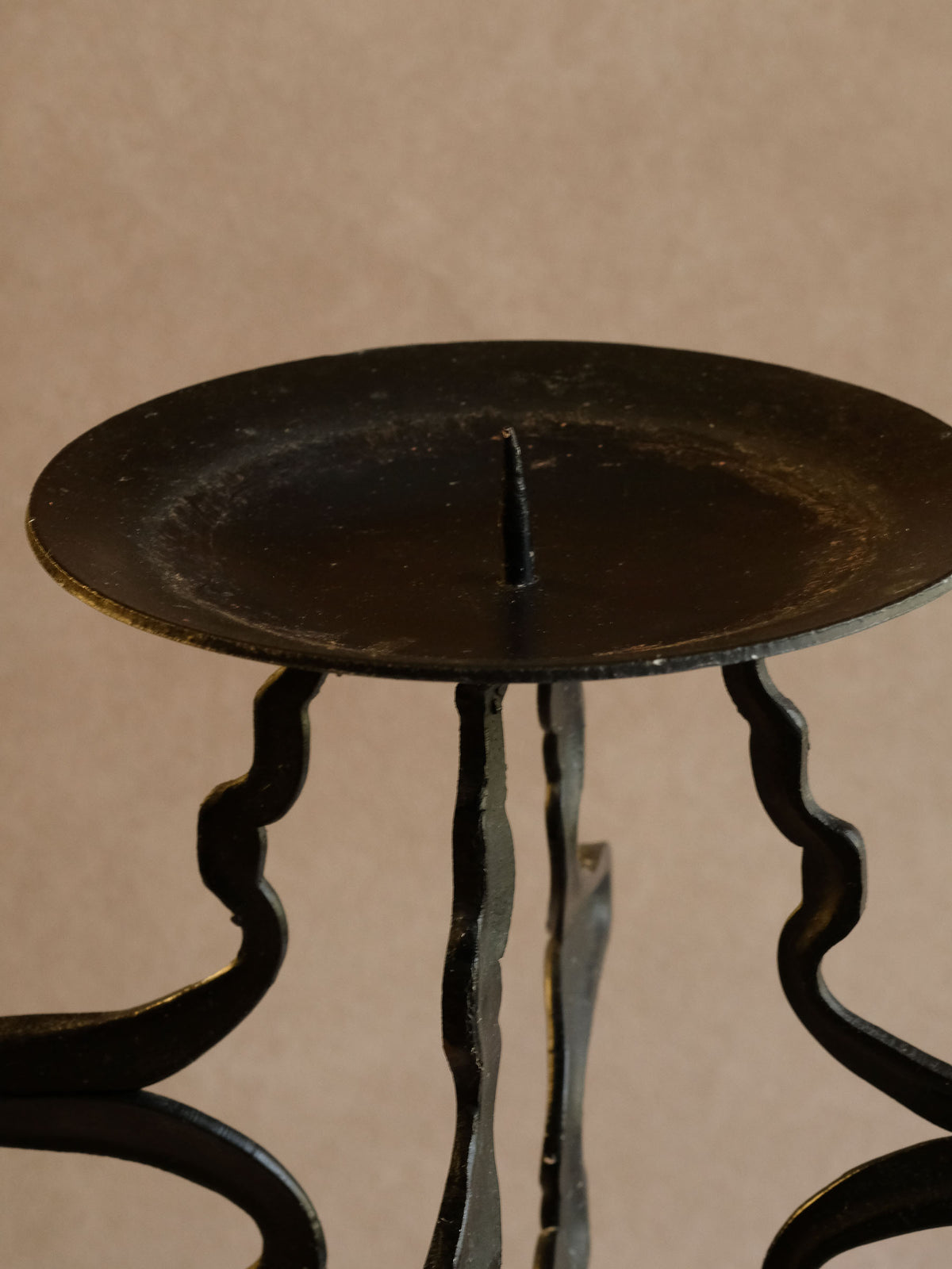 Close-up of the organically curved blackened iron stem and connecting branches.