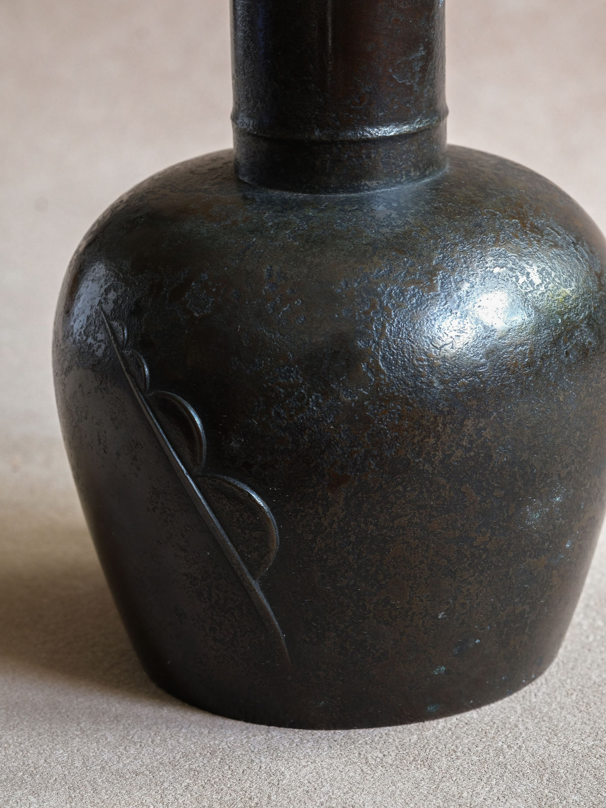 Close-up of Maruyama Fubo copper vase showing the subtle raised curved motif across the rounded body.