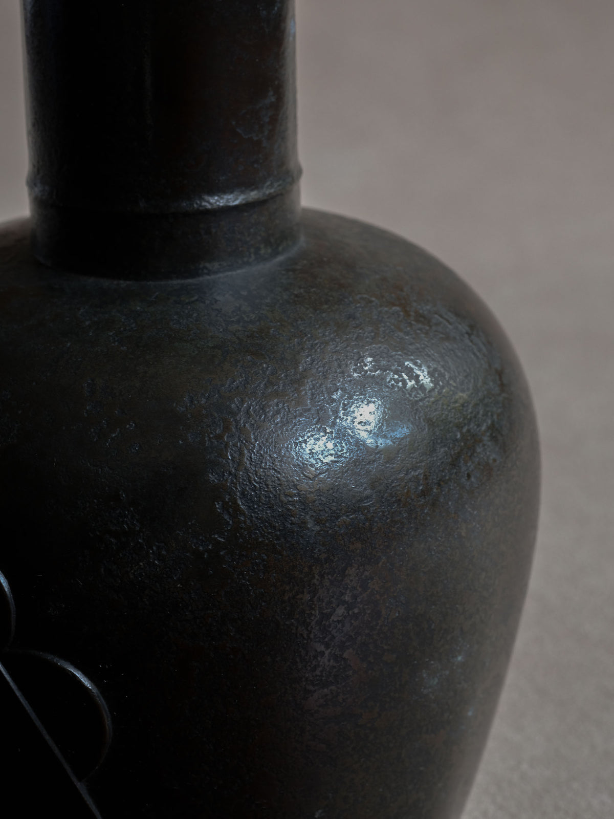 Detail of the dark cast copper surface on Maruyama Fubo vase, showing even aged tone and fine variation.