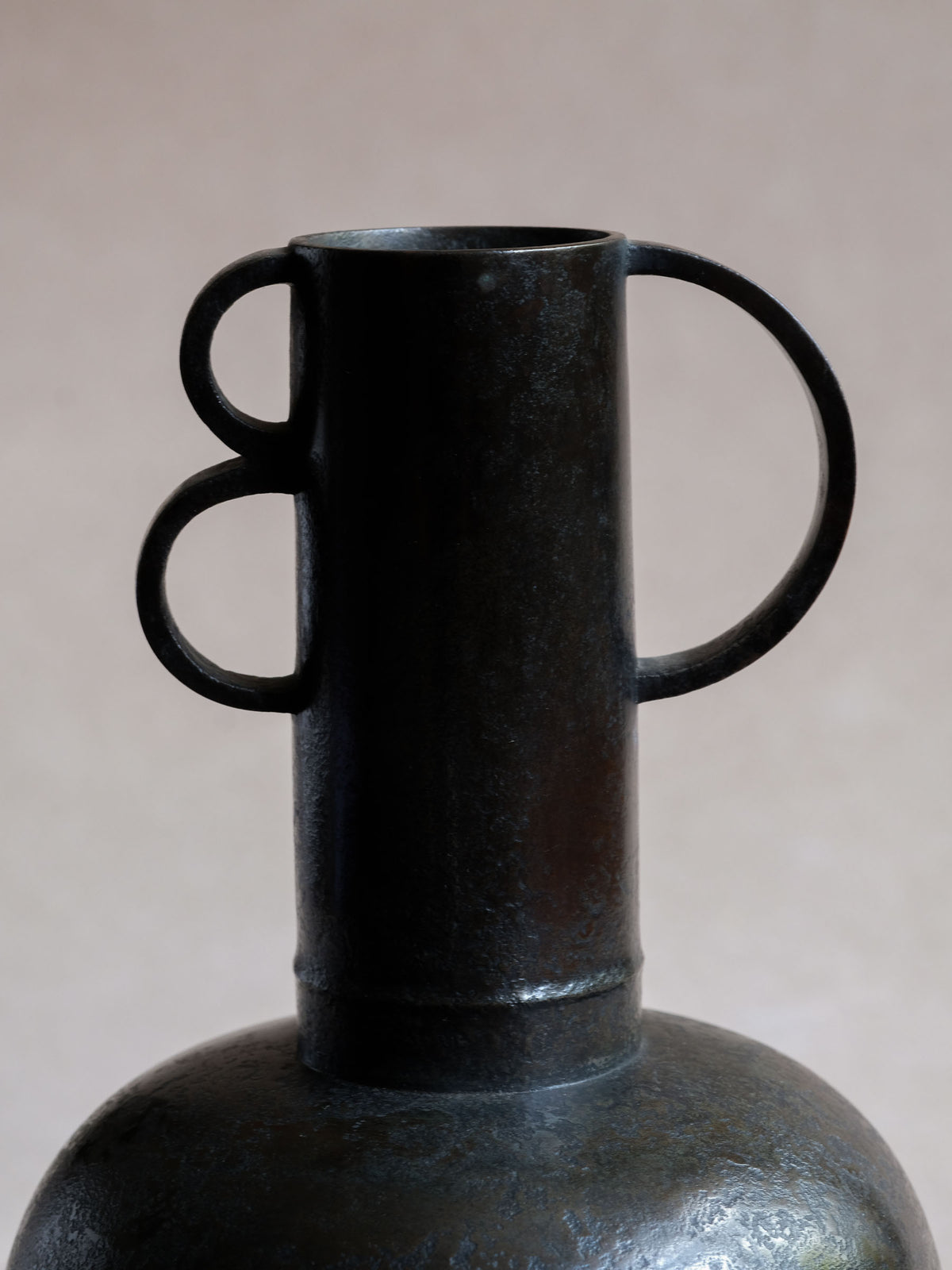 Close-up of geometric loop handles and cylindrical neck on Maruyama Fubo modernist copper vase.