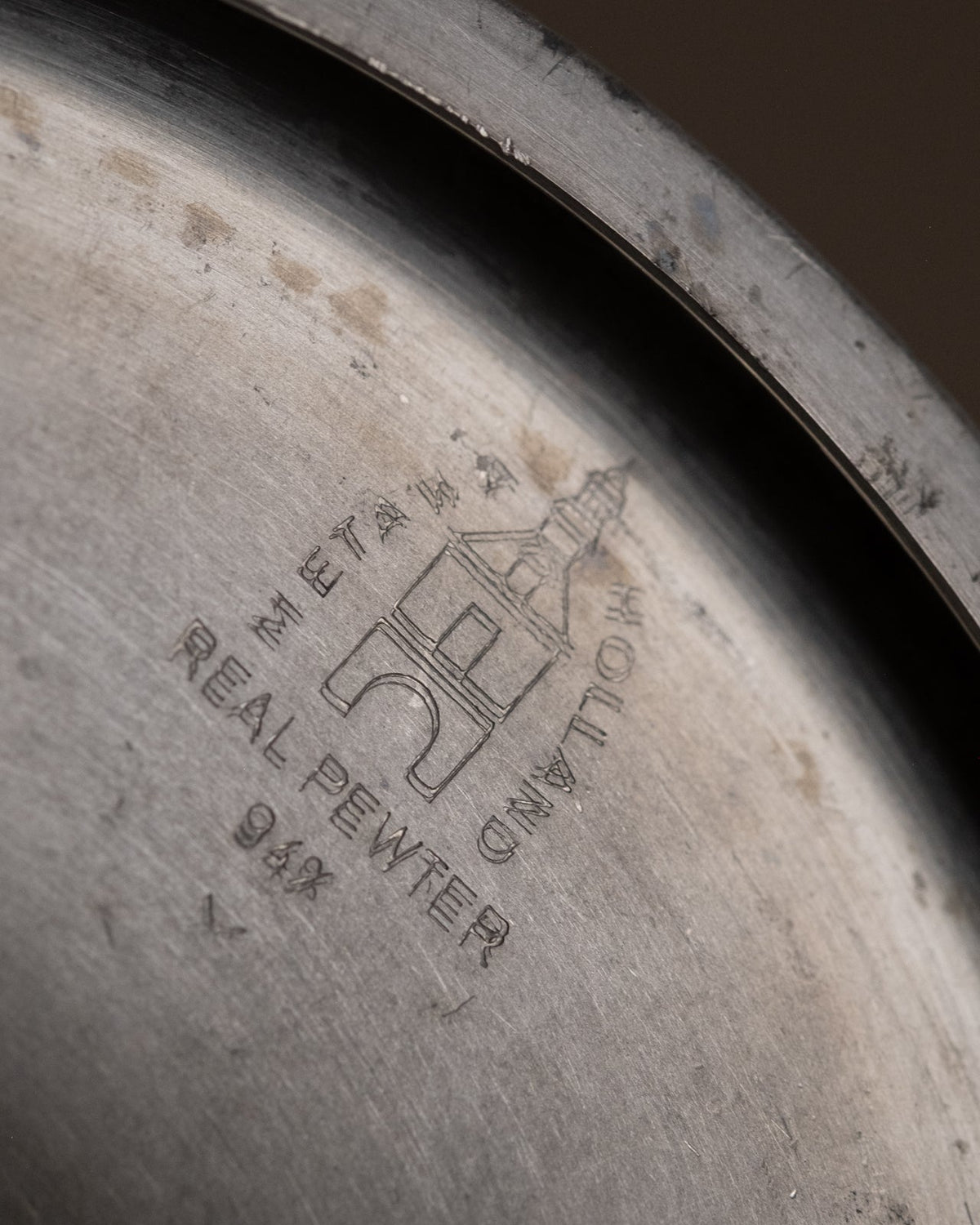 Underside mark on the candleholder reading Metawa Holland Real Pewter 94% with the tower emblem.