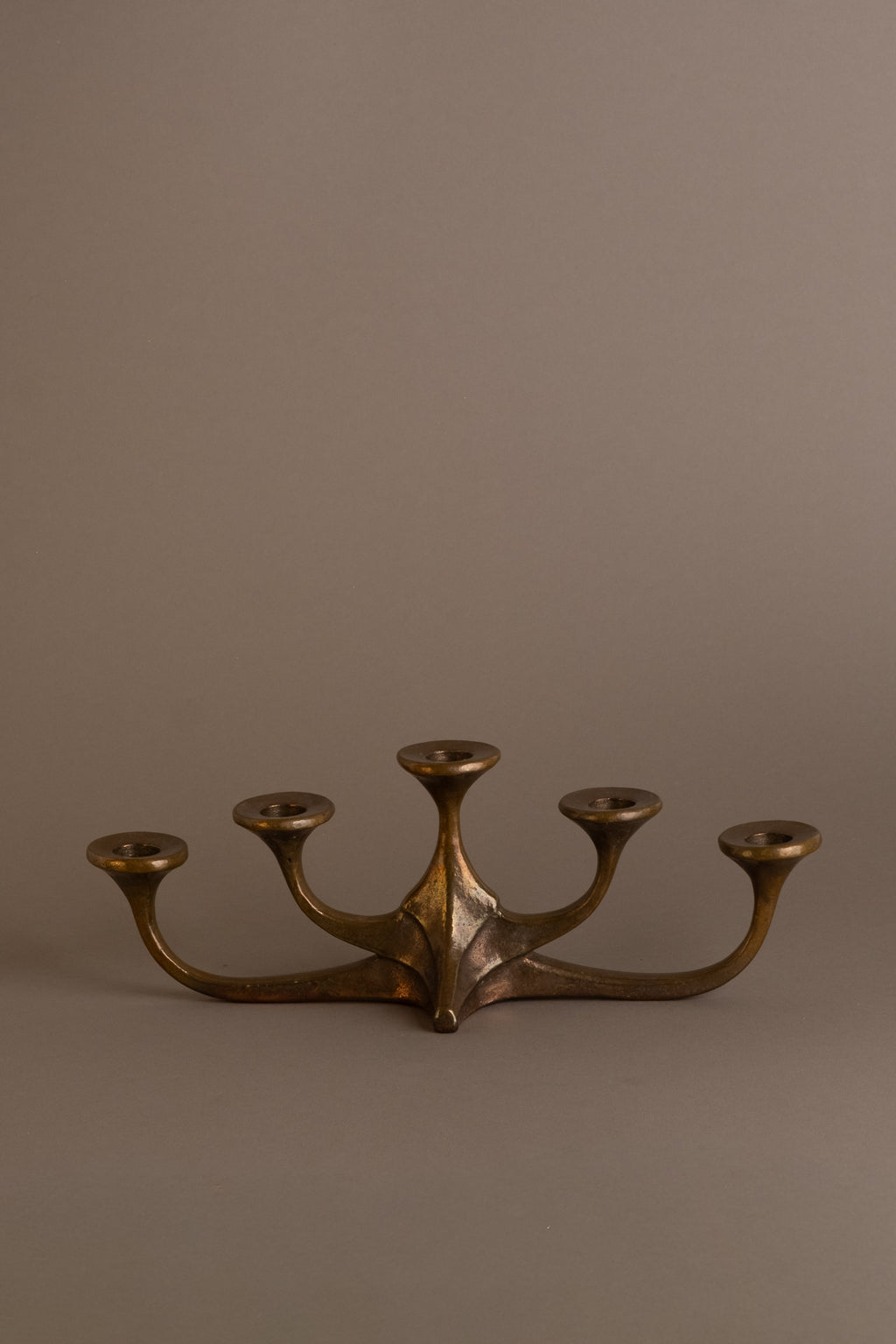 Front view of five-arm bronze candleholder, attributed to Michael Harjes, Germany.