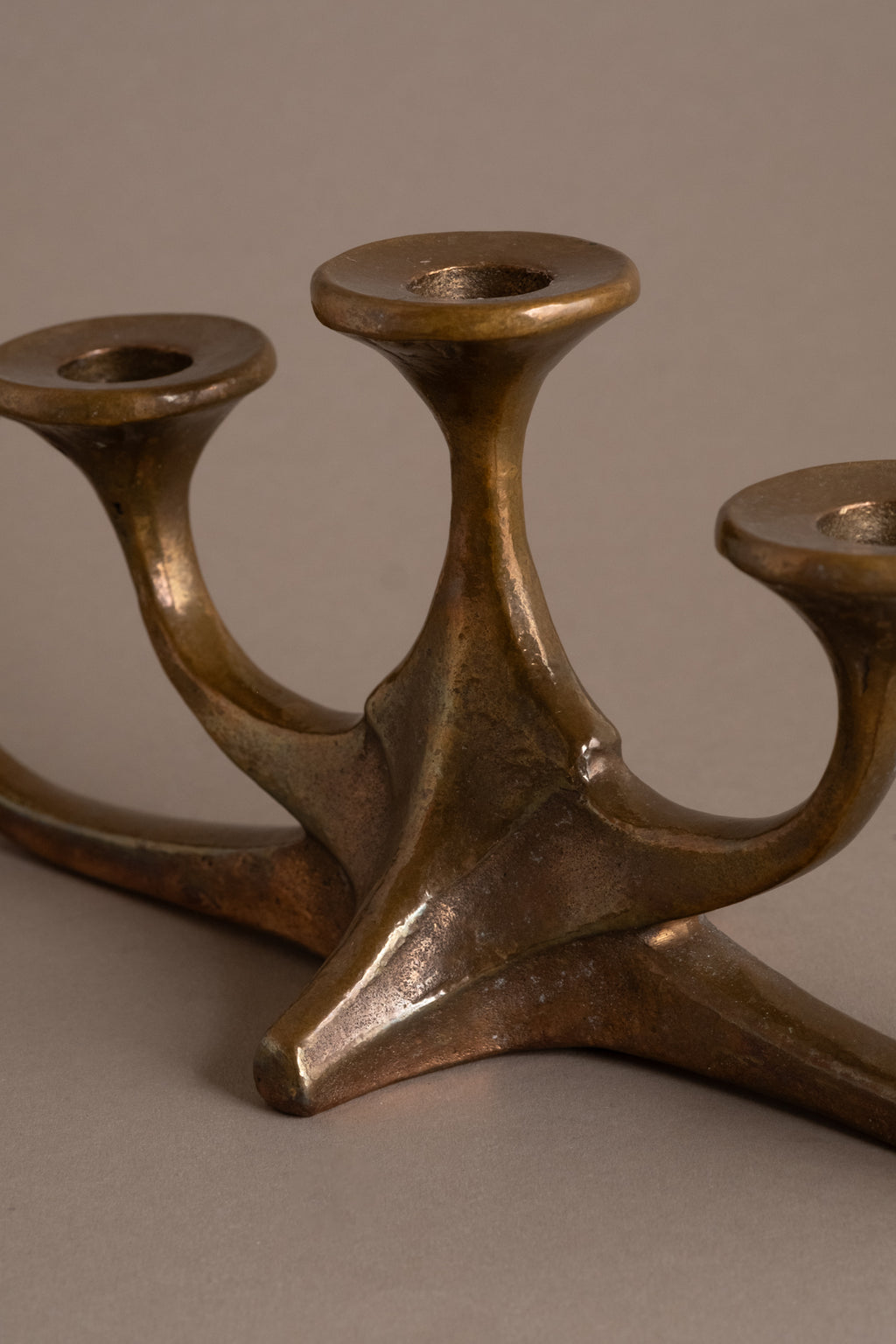 Detail of curved bronze arms and candle cups, Brutalist metalwork, 1960s–70s.