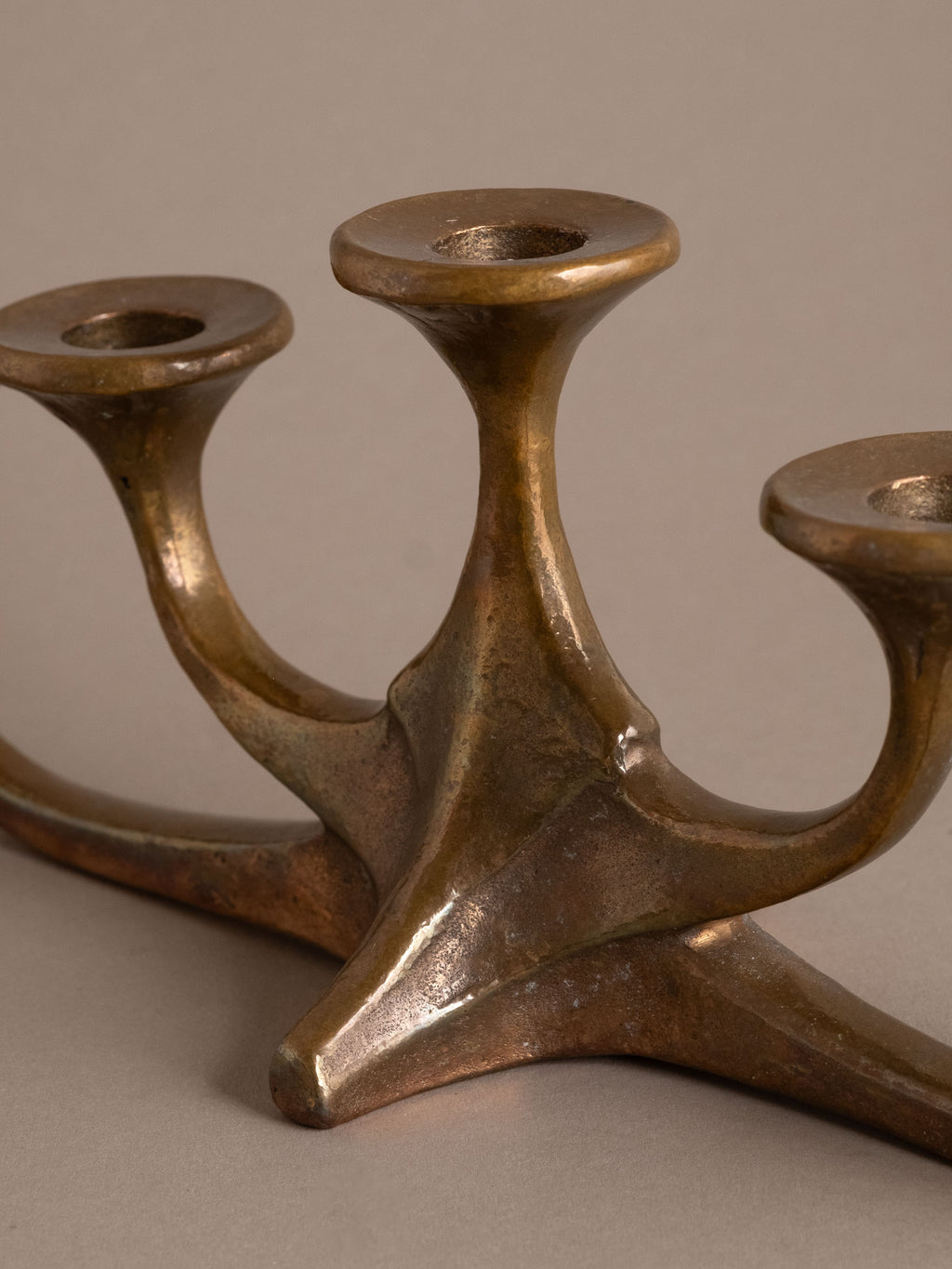 Detail of curved bronze arms and candle cups, Brutalist metalwork, 1960s–70s.