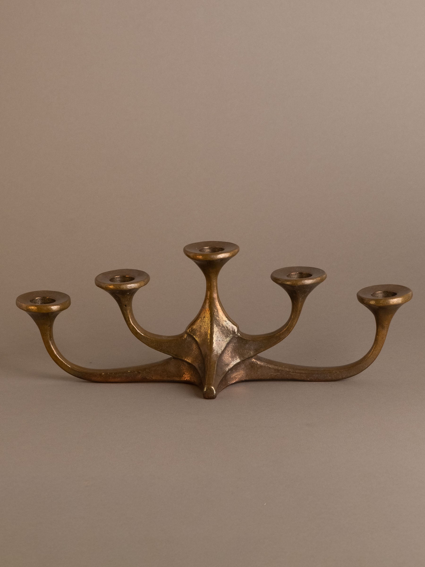 Front view of five-arm bronze candleholder, attributed to Michael Harjes, Germany.