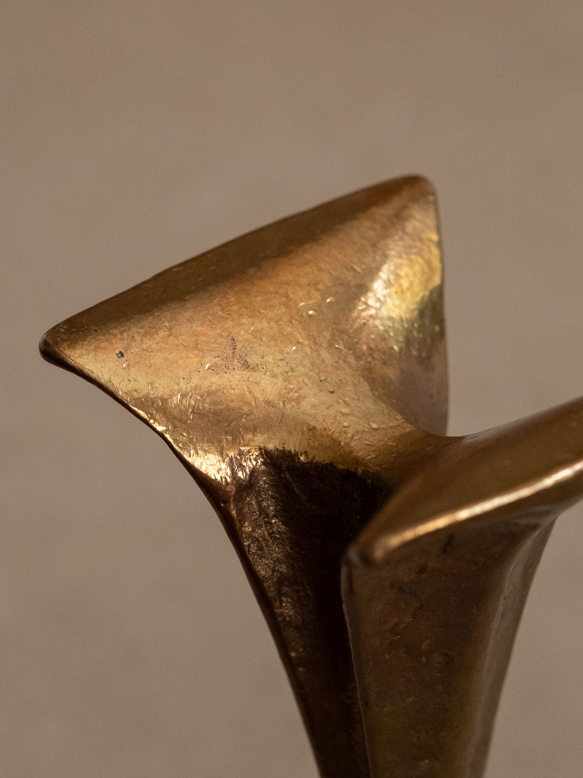 Close detail of the cast bronze surface and flared foot on the Michael Harjes candleholder.