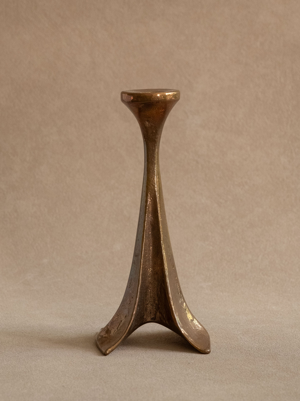 Front view of a Michael Harjes single-stem bronze candleholder, Germany, c. 1960s–70s, with tripod base.