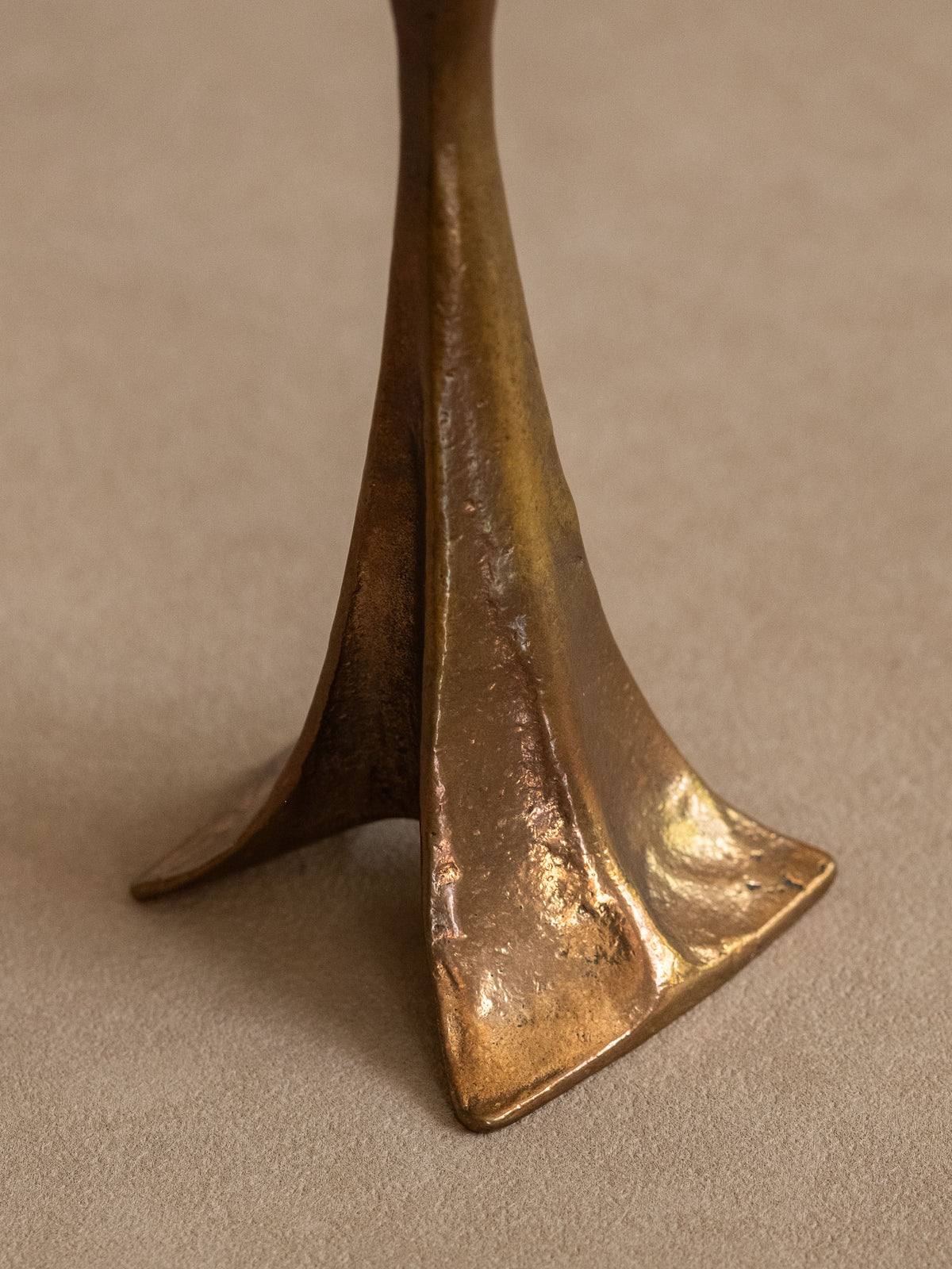Close detail of the tripod base and textured aged bronze surface.