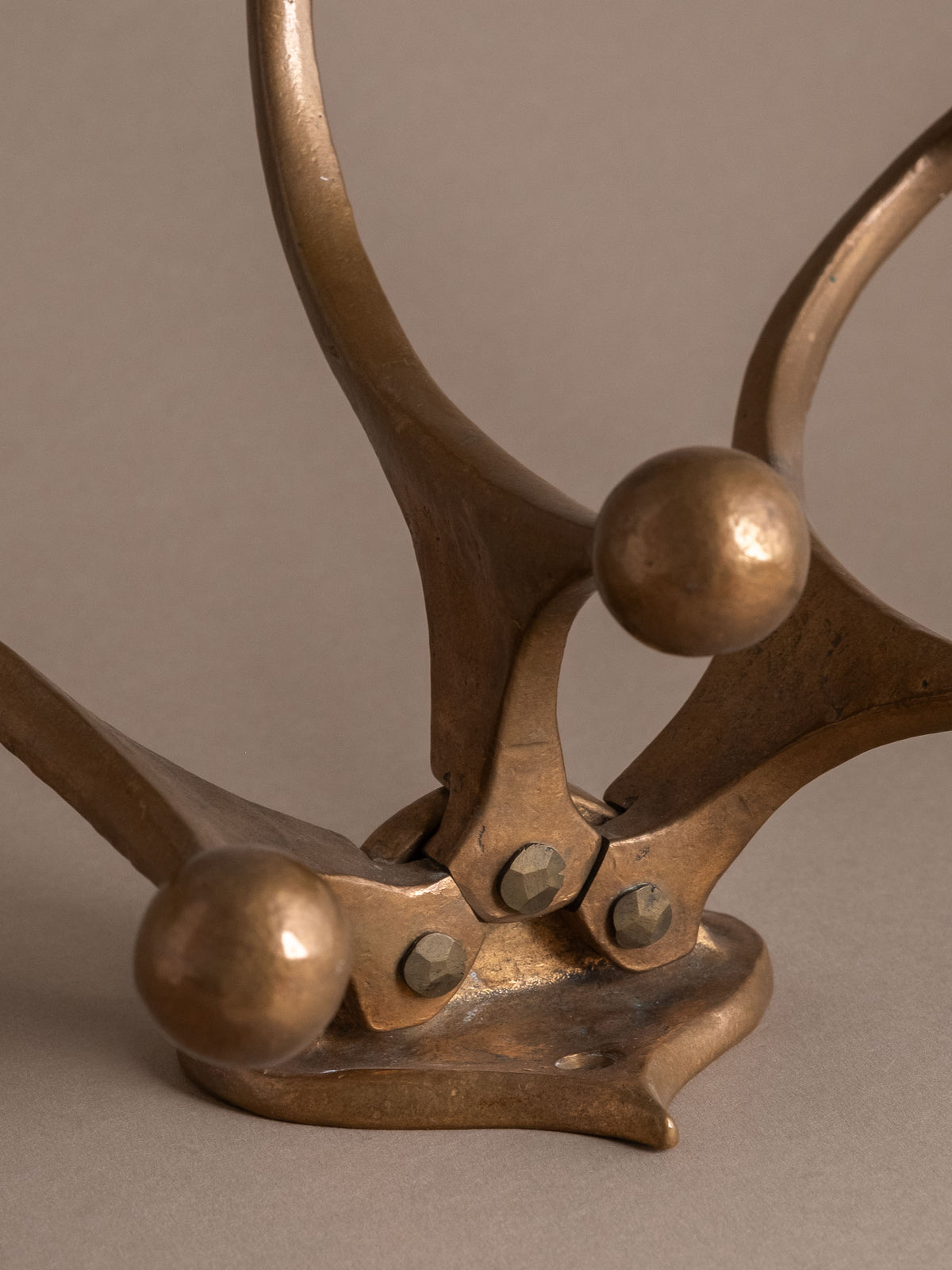 Close detail of the jointed bronze construction, fasteners and aged patina.