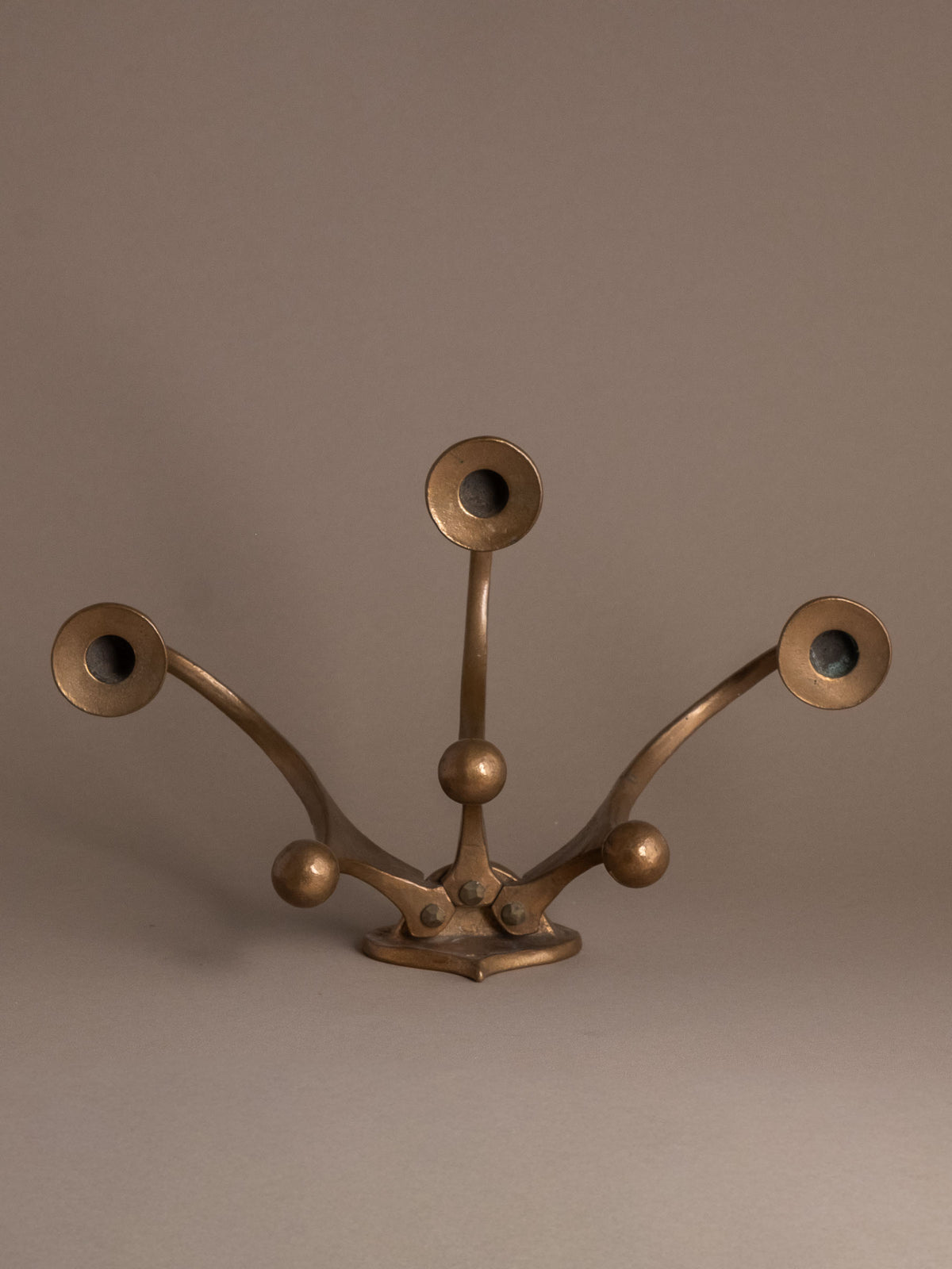 Straight front view of the Michael Harjes three-arm wall candleholder showing its wide symmetrical form.