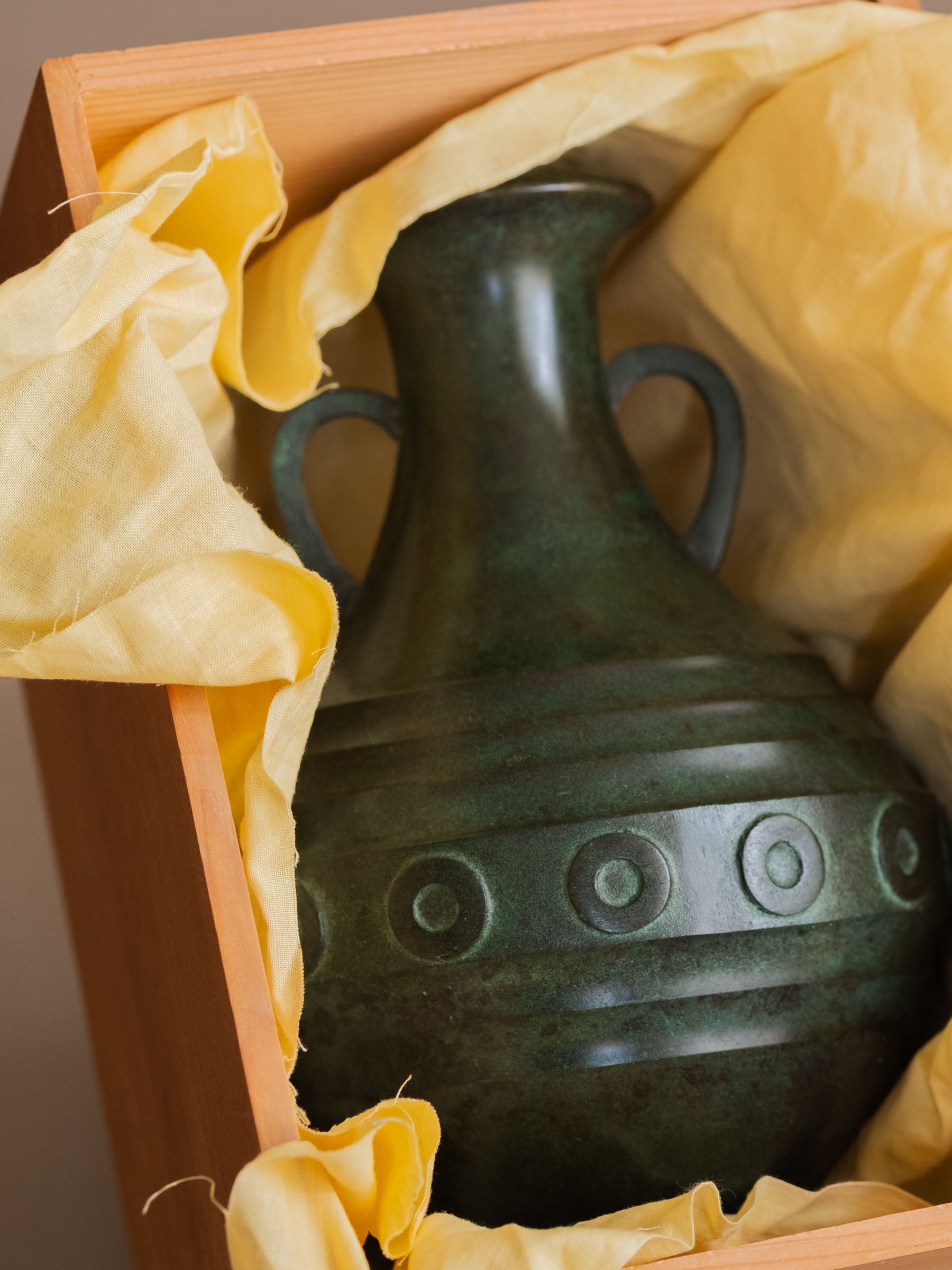 Japanese bronze vase resting inside original tomobako presentation box lined with yellow cloth.