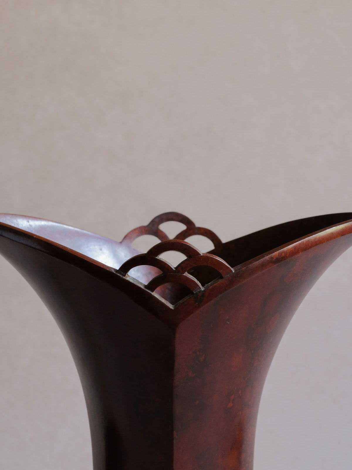 Close-up of Nakajima Yasumi II 1961 bronze vase with flared sculptural rim and geometric openwork arches.