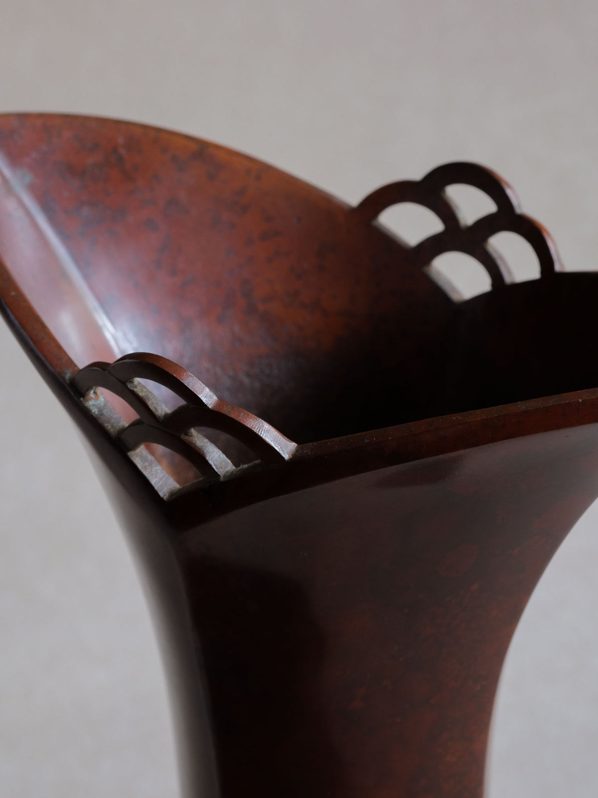 Close-up of the flared rim and triple-arched openwork on Nakajima Yasumi II sculptural bronze vase.