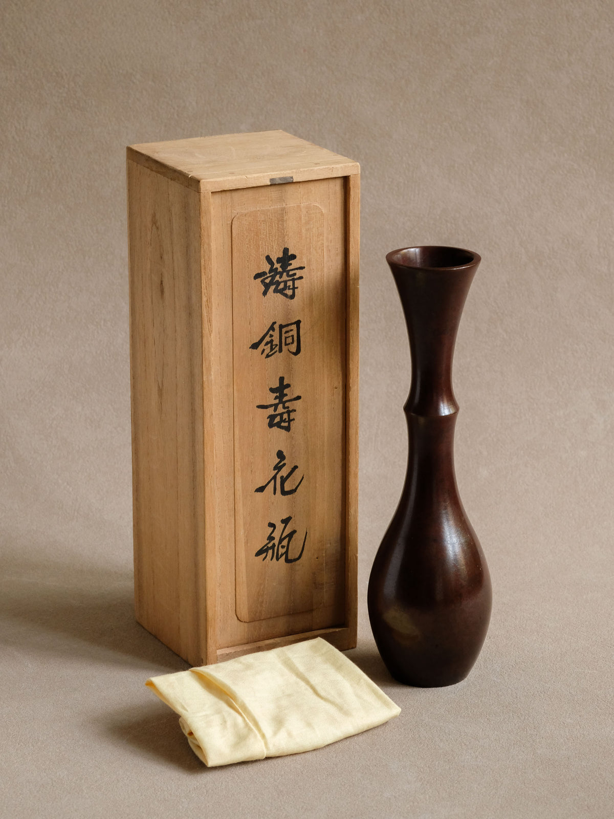 Close view of the bronze surface and tapered profile of the Japanese Nakajima Yasumi vase.