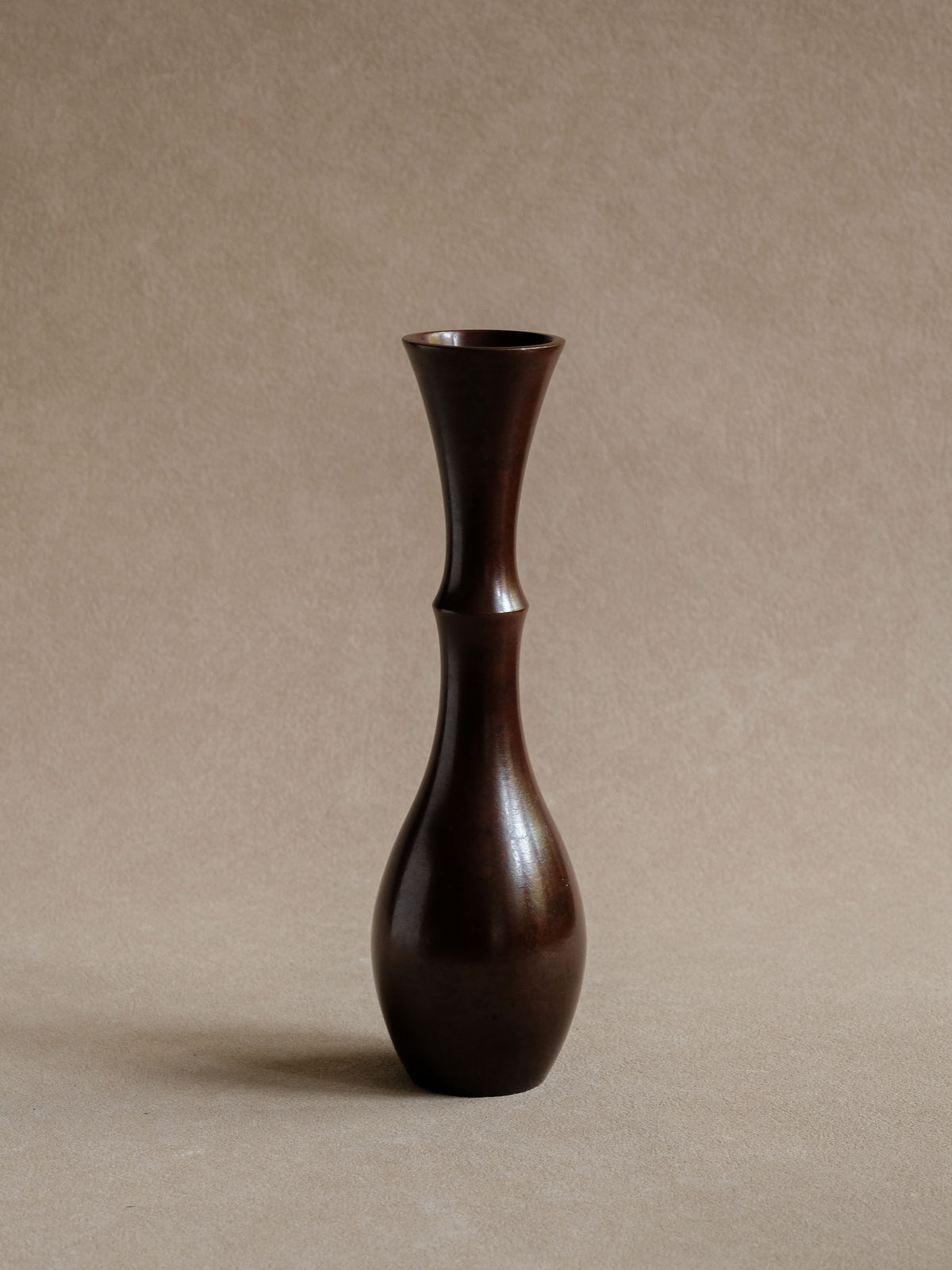 Slender Japanese bronze vase by Nakajima Yasumi with narrow neck and dark patinated form.