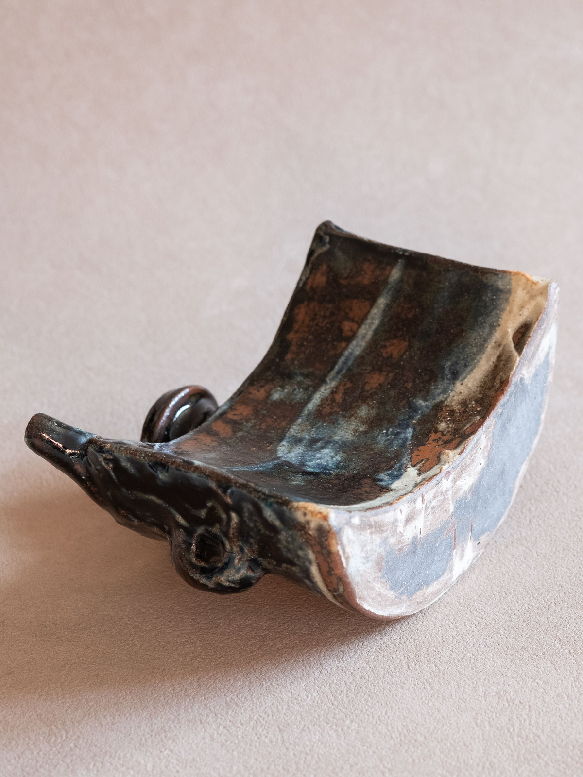 Top view of the curved Okinawan dachibin showing the openings, side lugs and dark glazed ceramic surface.