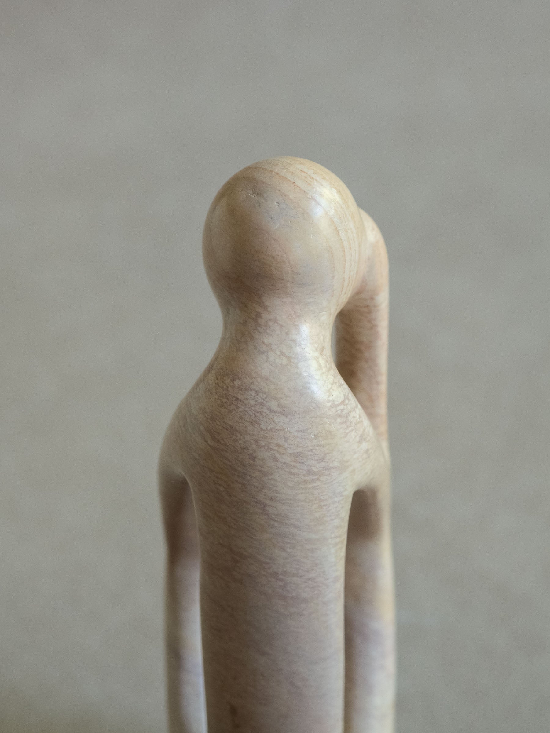 Upper profile detail of the abstract Kisii soapstone sculpture, showing the smooth pale stone and elongated carved form.
