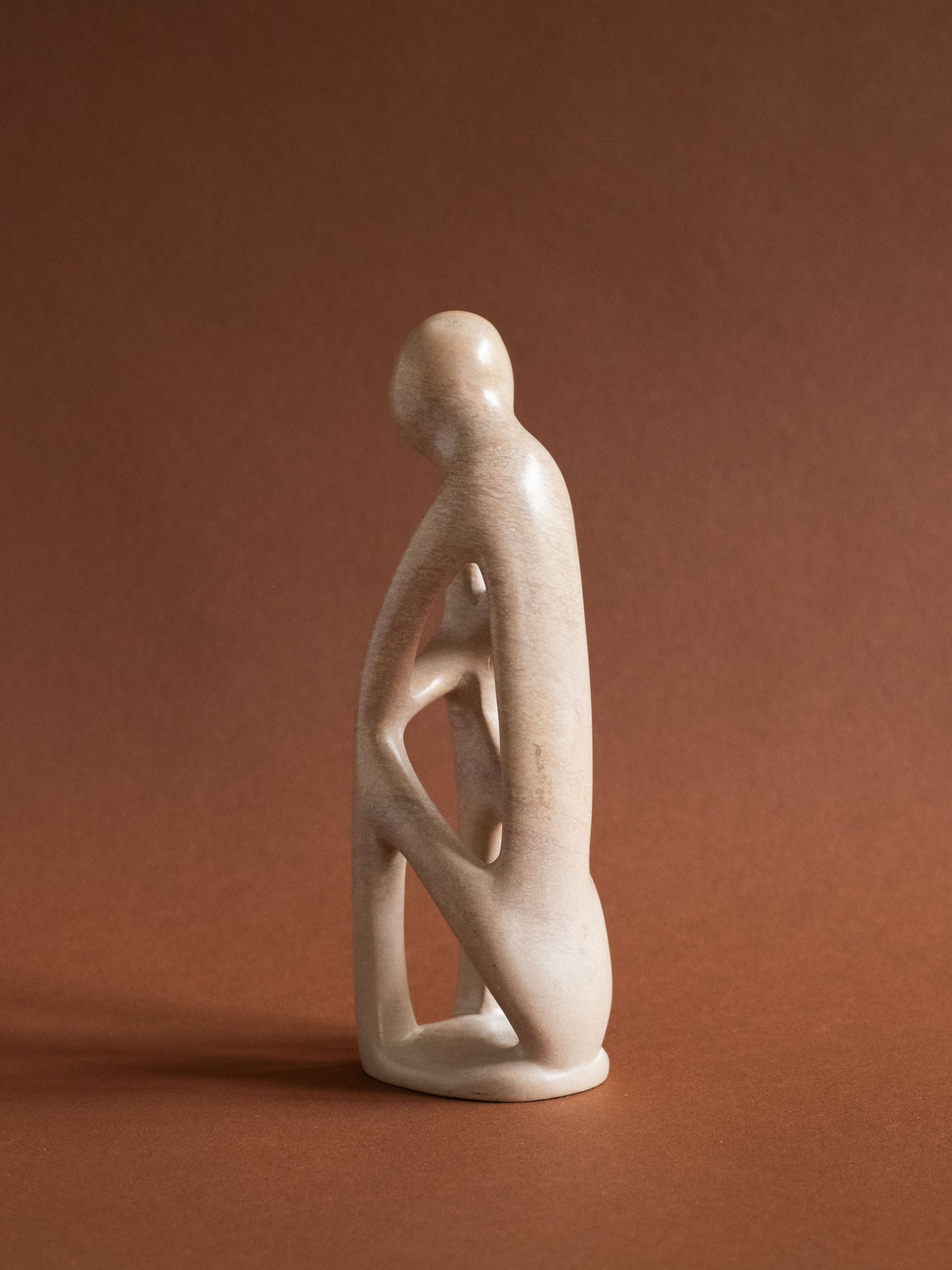 Full side view of the Kenyan soapstone sculpture showing the narrow profile and carved openings.