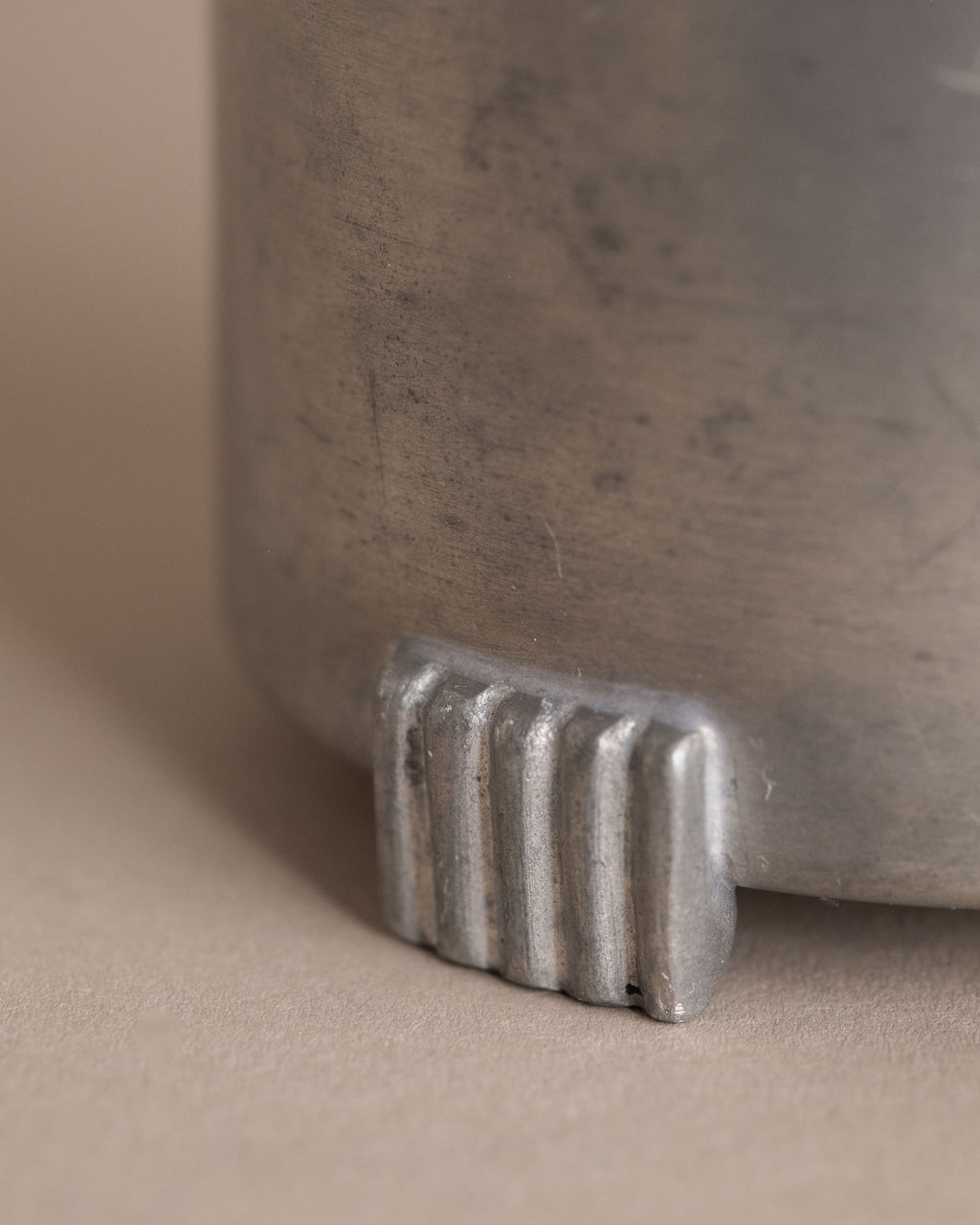 Detail view of one ribbed foot on a small Savo Tinn pewter lidded box from Norway.