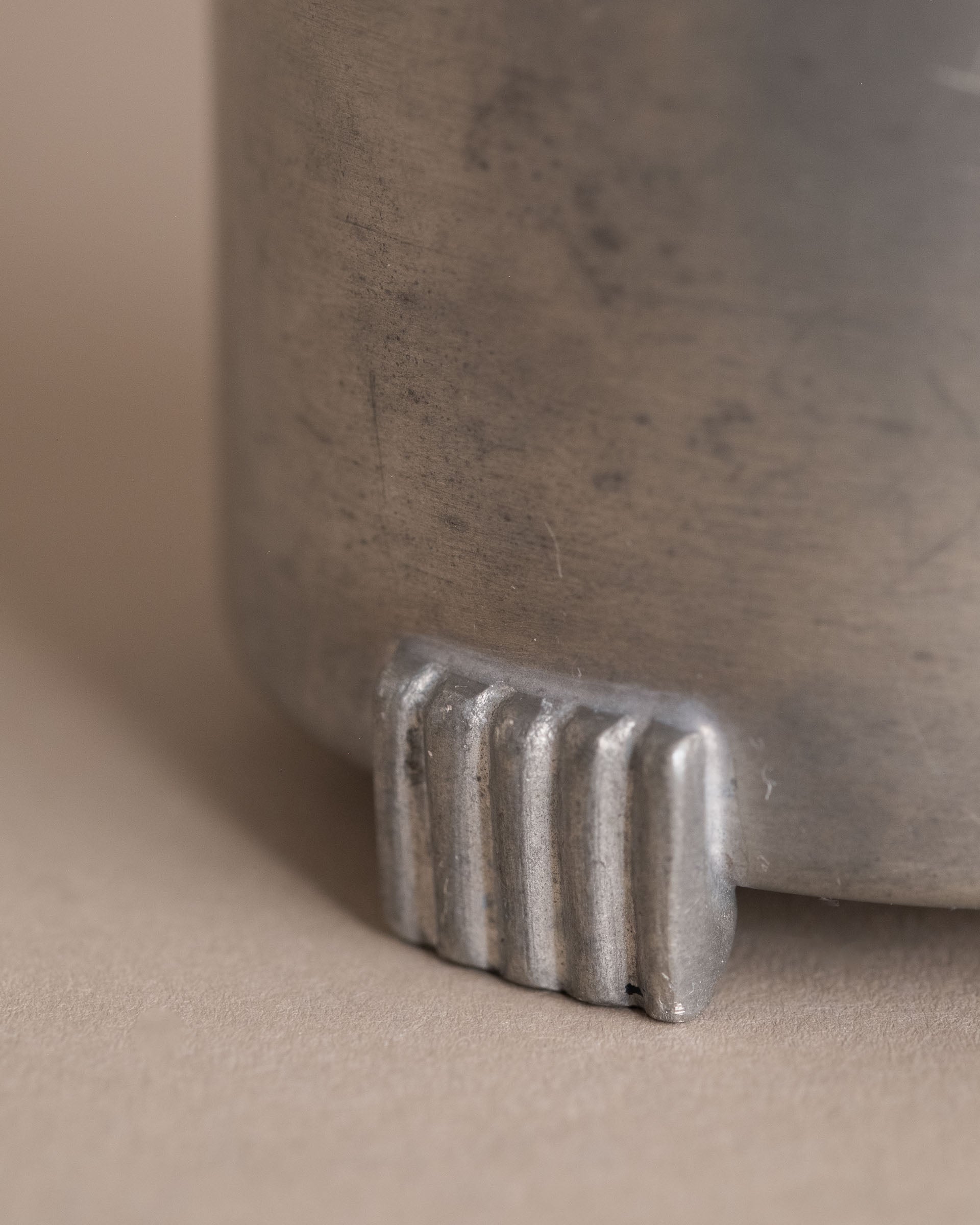 Detail view of one ribbed foot on a small Savo Tinn pewter lidded box from Norway.