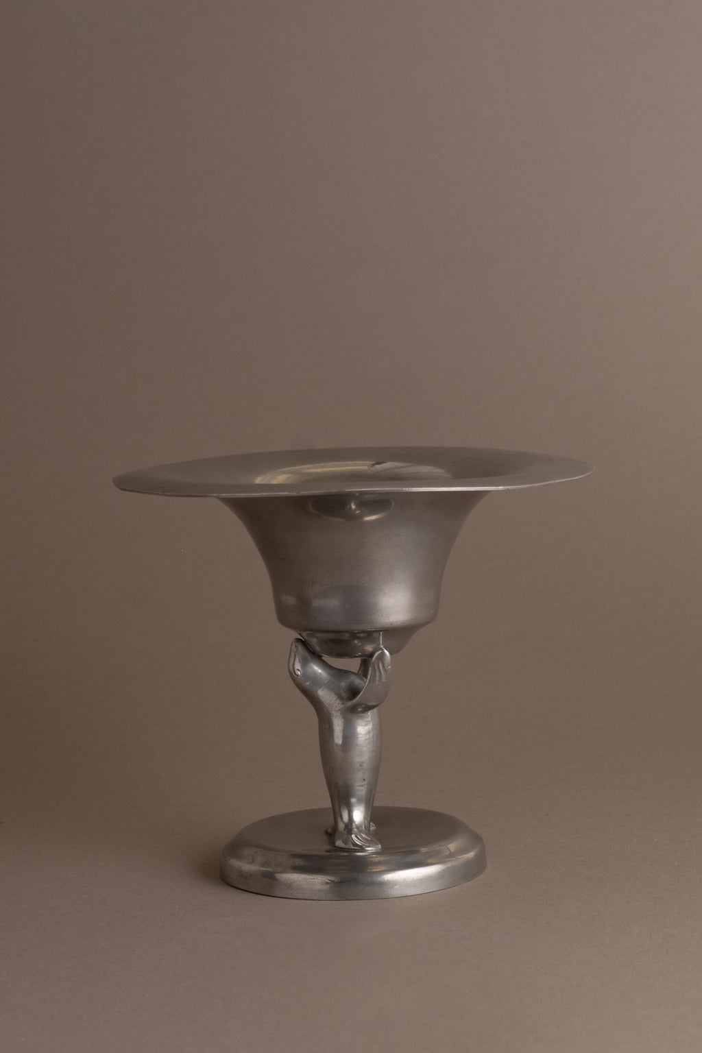 Front view of Dahlströms Tenn pewter pedestal bowl with stylised sea lion stem, Sweden, c. 1930s.