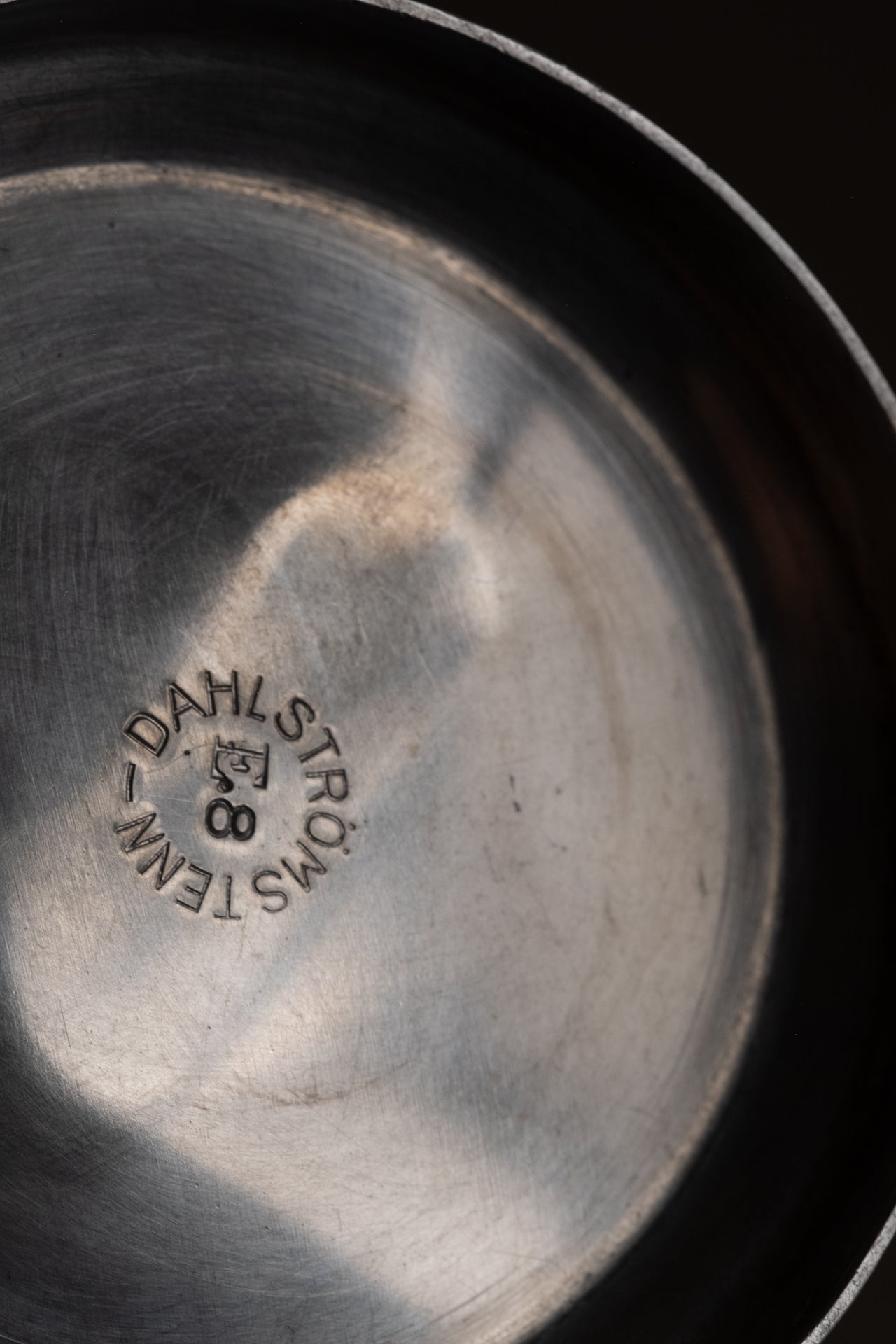 Close-up of Dahlströms Tenn maker’s mark stamped inside the pewter pedestal bowl.