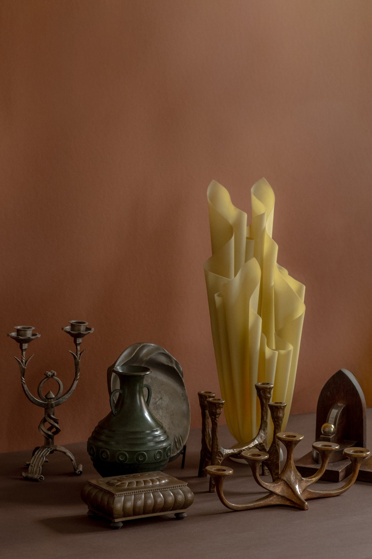 Antique and vintage metal design objects including Japanese patinated bronze vase, sculptural bronze candleholders, wrought iron candleholder, WMF brass jewellery box, Kayserzinn pewter plate and Georgia Jacob Athena lamp.