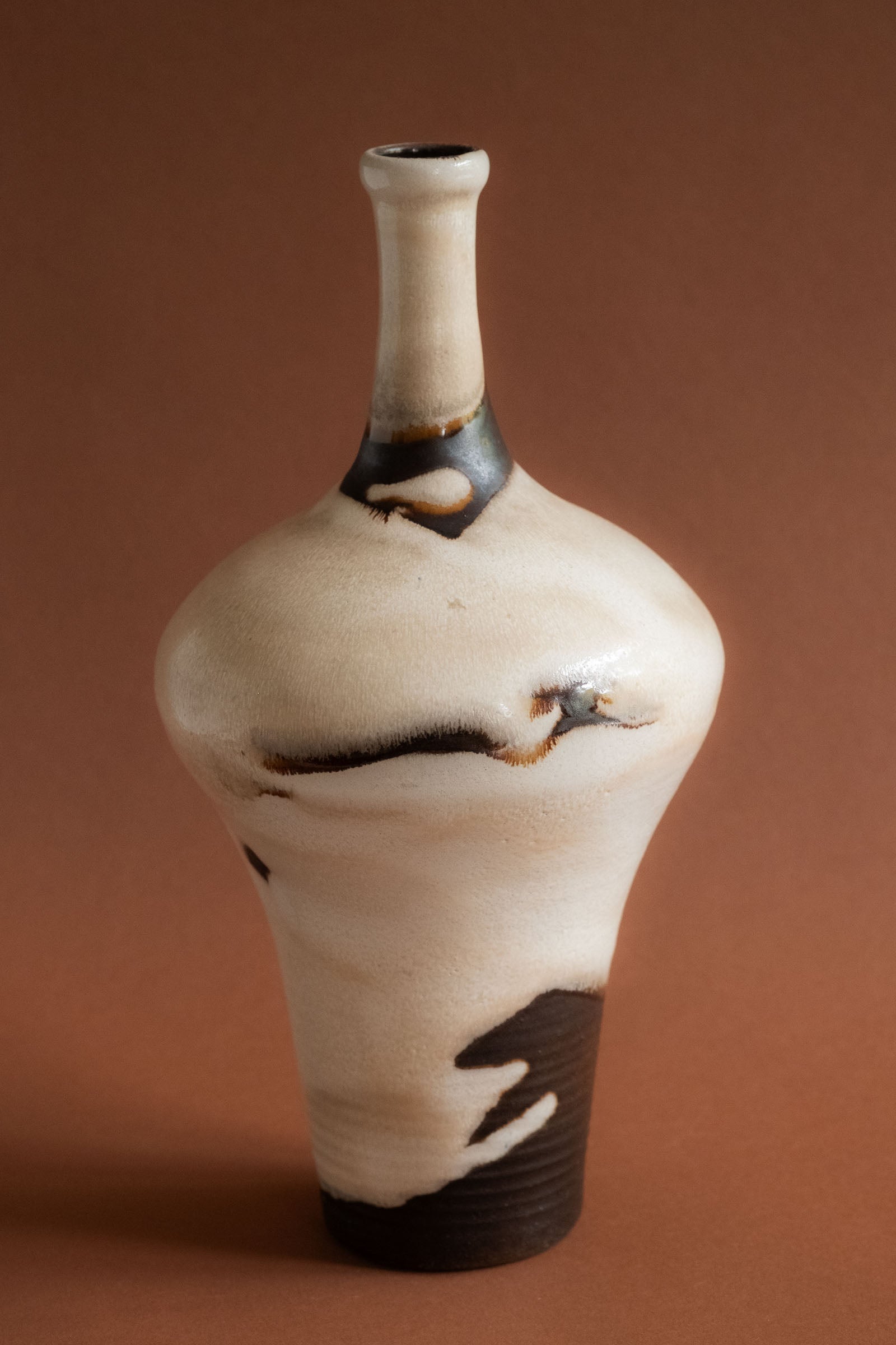Full view of the 1960s Elly and Wilhelm Kuch studio ceramic vase with bulbous body and abstract black glaze.