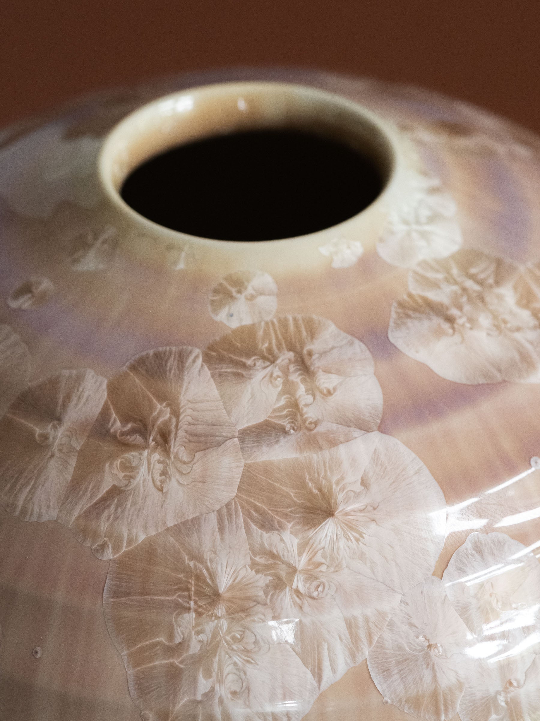 Close view of the vase mouth and surrounding crystalline glaze, with large natural crystal blooms across the shoulder.