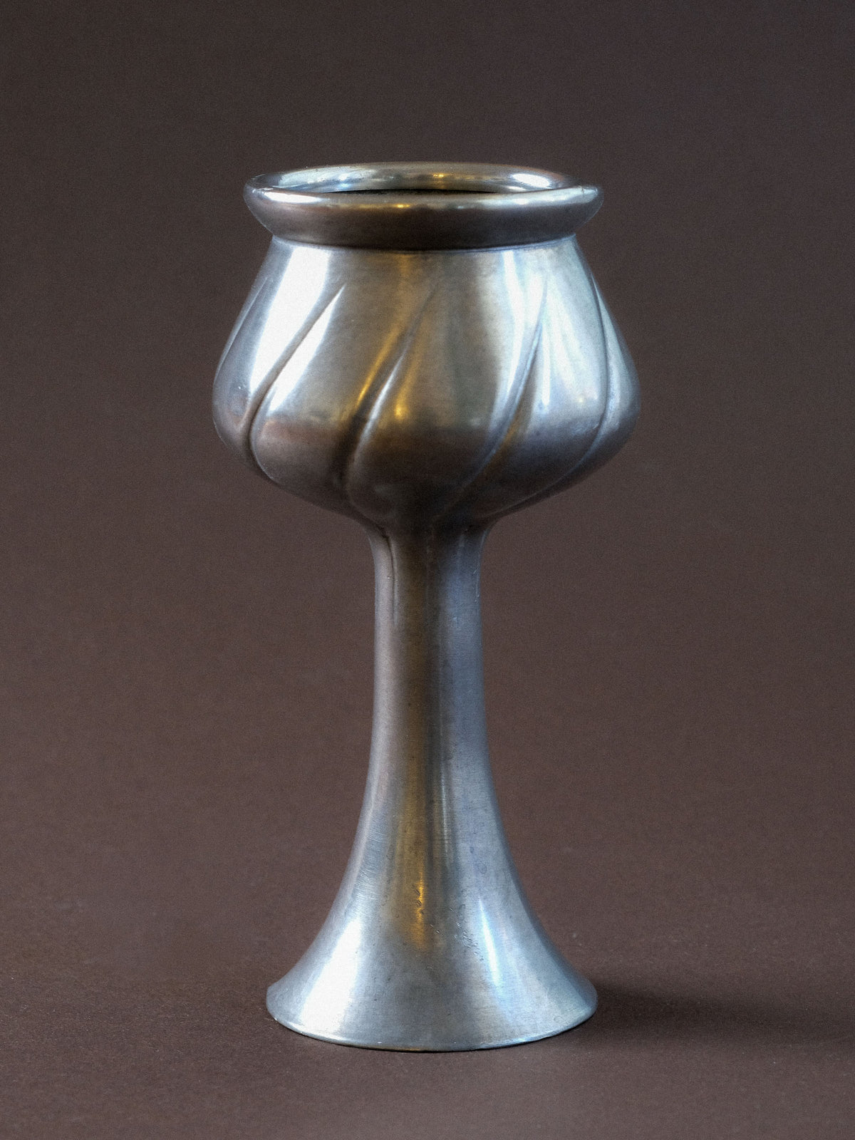 Alternate full view of the small pewter vase showing its elongated neck, flared rim and sculptural lower body.