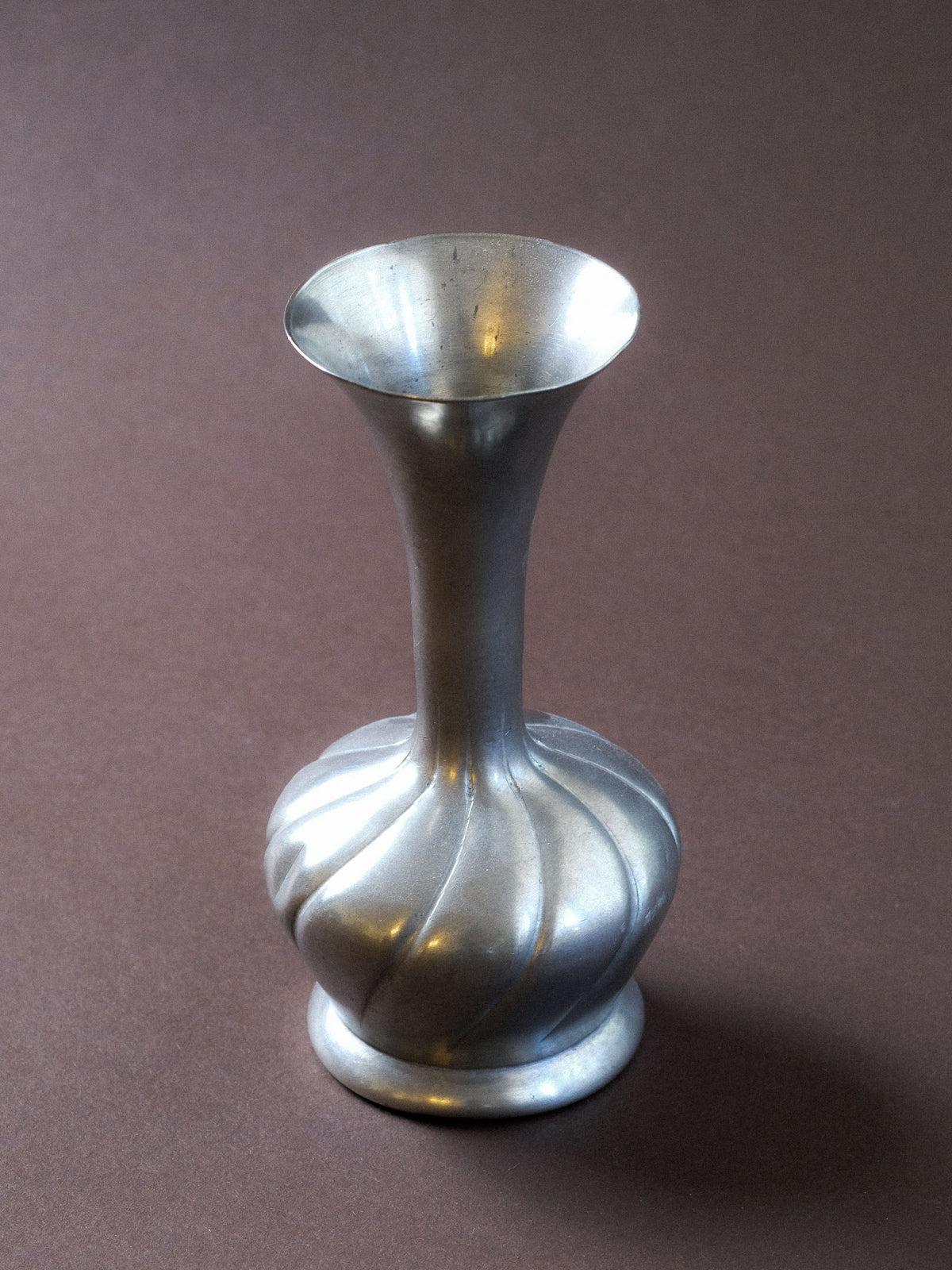 Vintage 95% pewter spiral vase, front view showing the rounded fluted body, narrow neck and flared mouth.