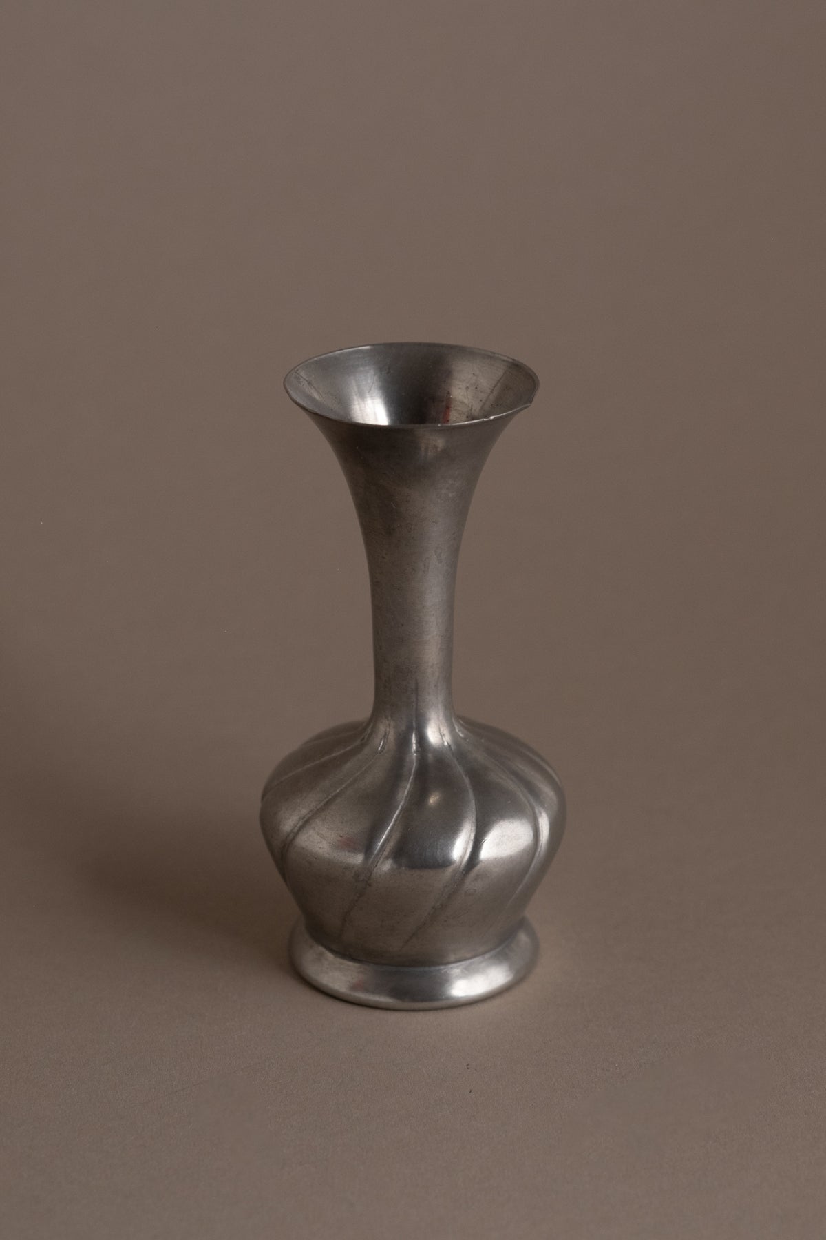 Full view of the small vintage pewter vase with spiral-fluted lower body and trumpet-shaped opening.