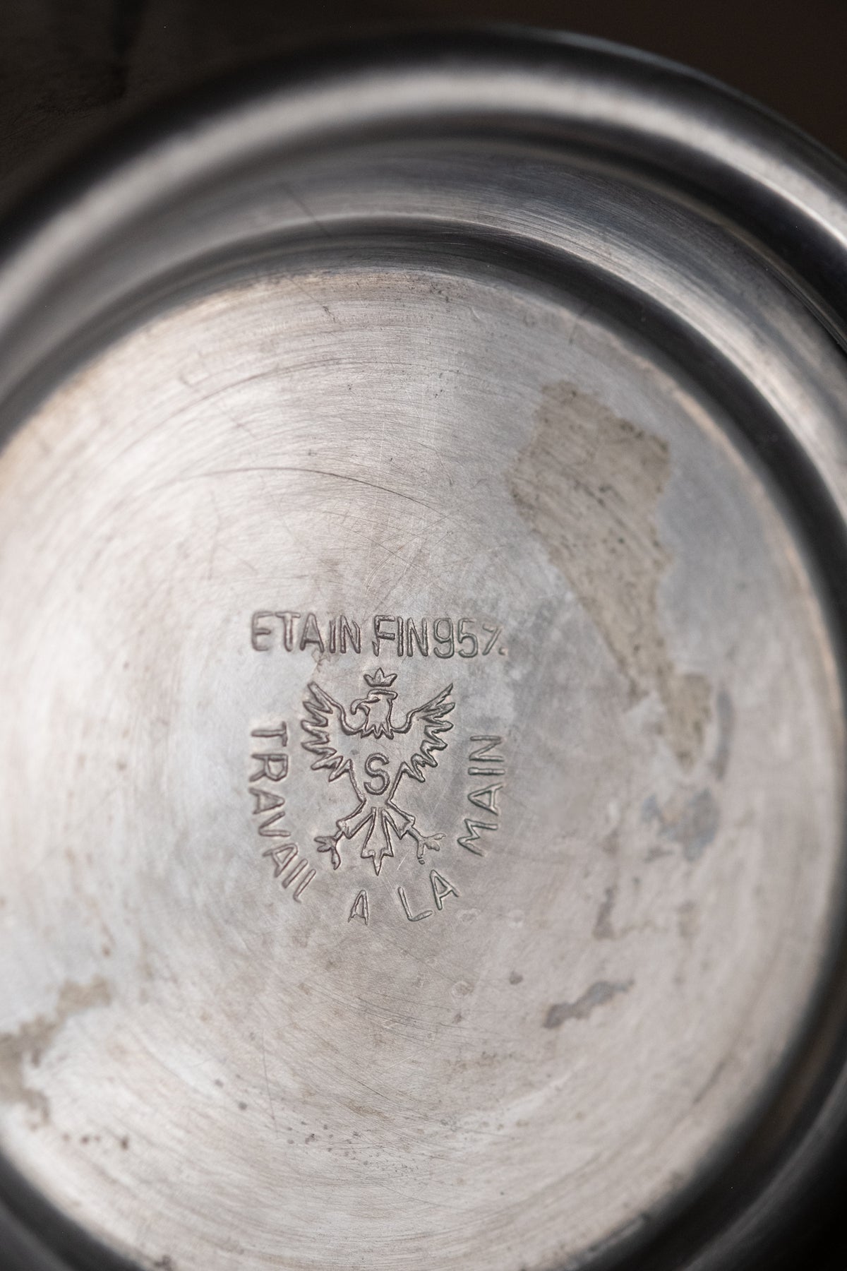 Underside of the pewter vase showing the ÉTAIN FIN 95% and TRAVAIL À LA MAIN marks.