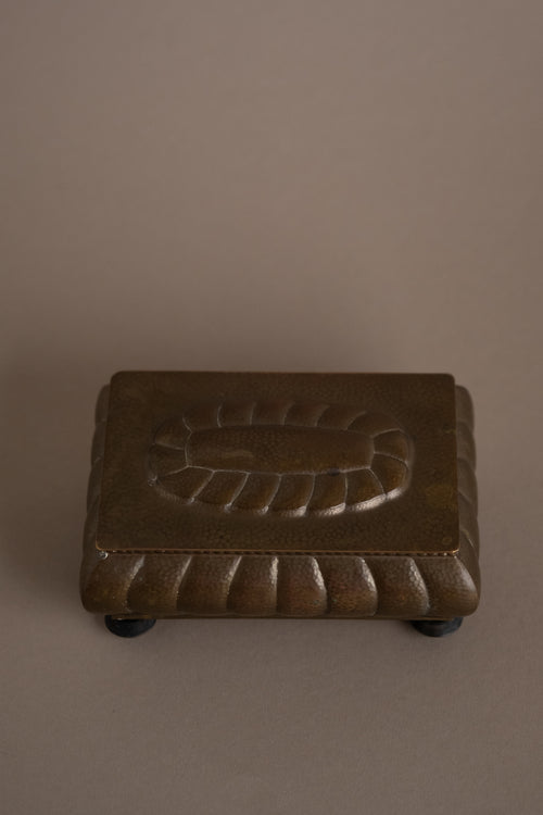 Top view of closed WMF hammered brass jewellery box on Bakelite feet, Germany, 1928–1935.
