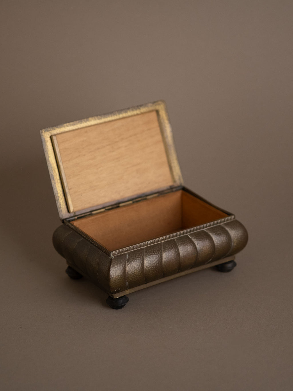 WMF hammered brass jewellery box open to show wooden interior lining, Bakelite feet, Germany, 1928–1935.