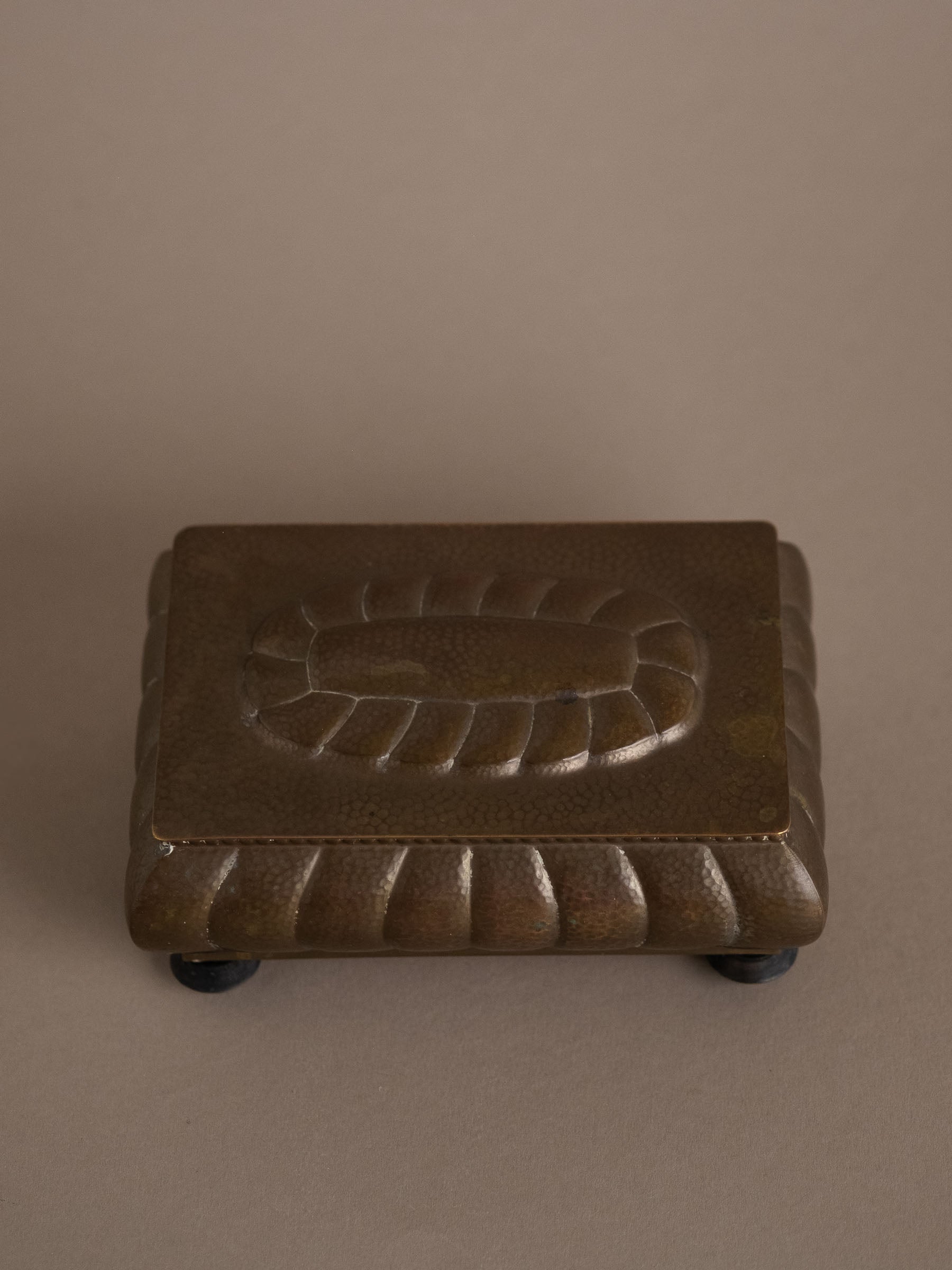 Top view of closed WMF hammered brass jewellery box on Bakelite feet, Germany, 1928–1935.
