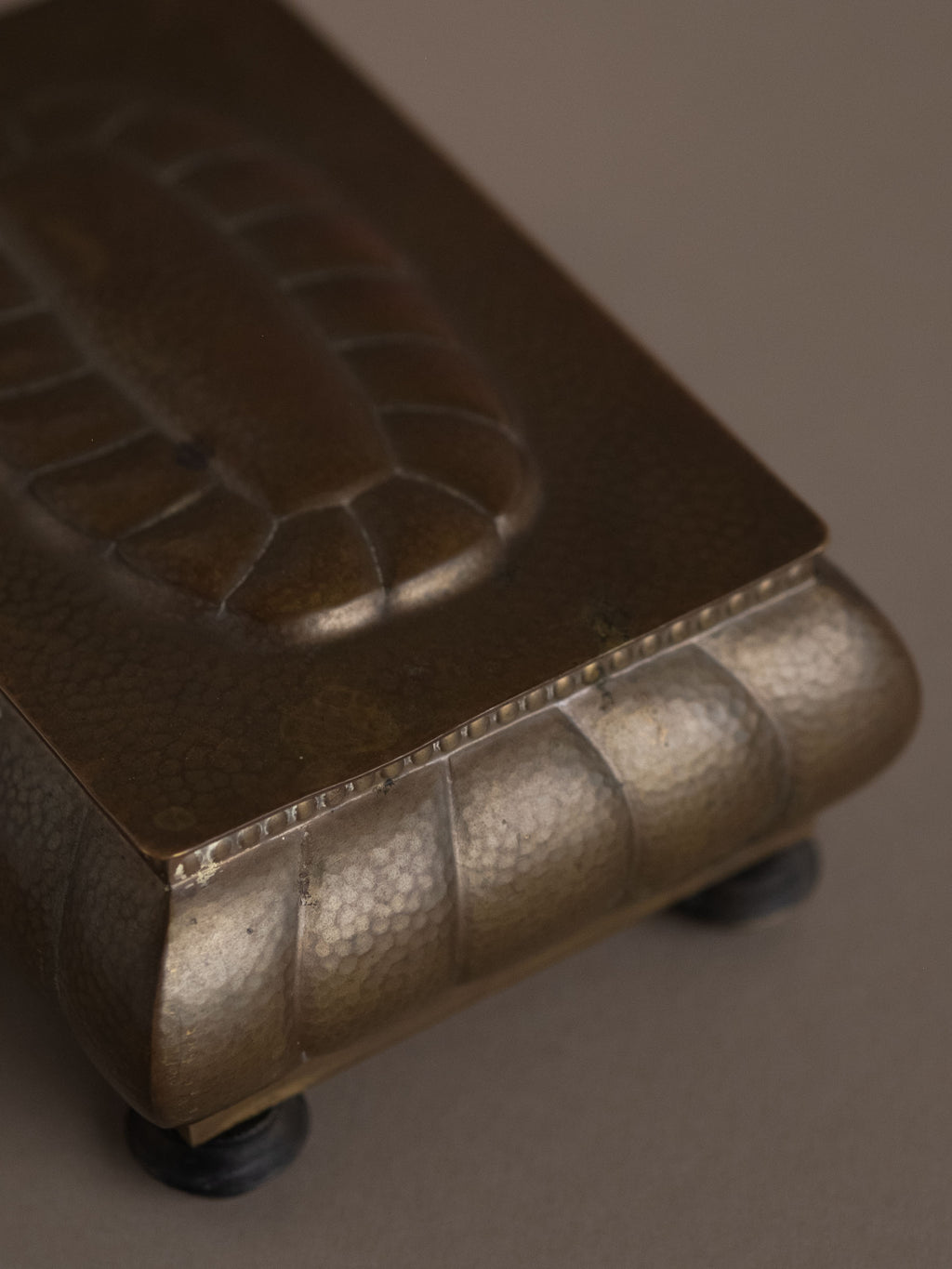 Detail of hammered brass surface and lid edge on WMF jewellery box with Bakelite feet, Germany, 1928–1935.