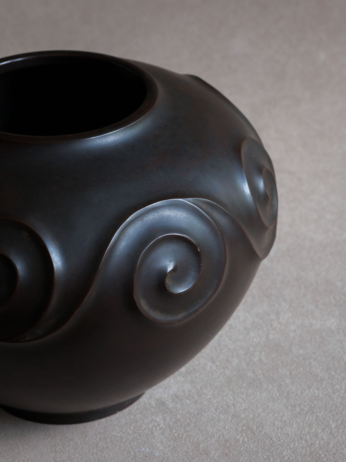 Detail of the sculpted spiral relief and dark brown bronze surface on Yashima Boshū vase.