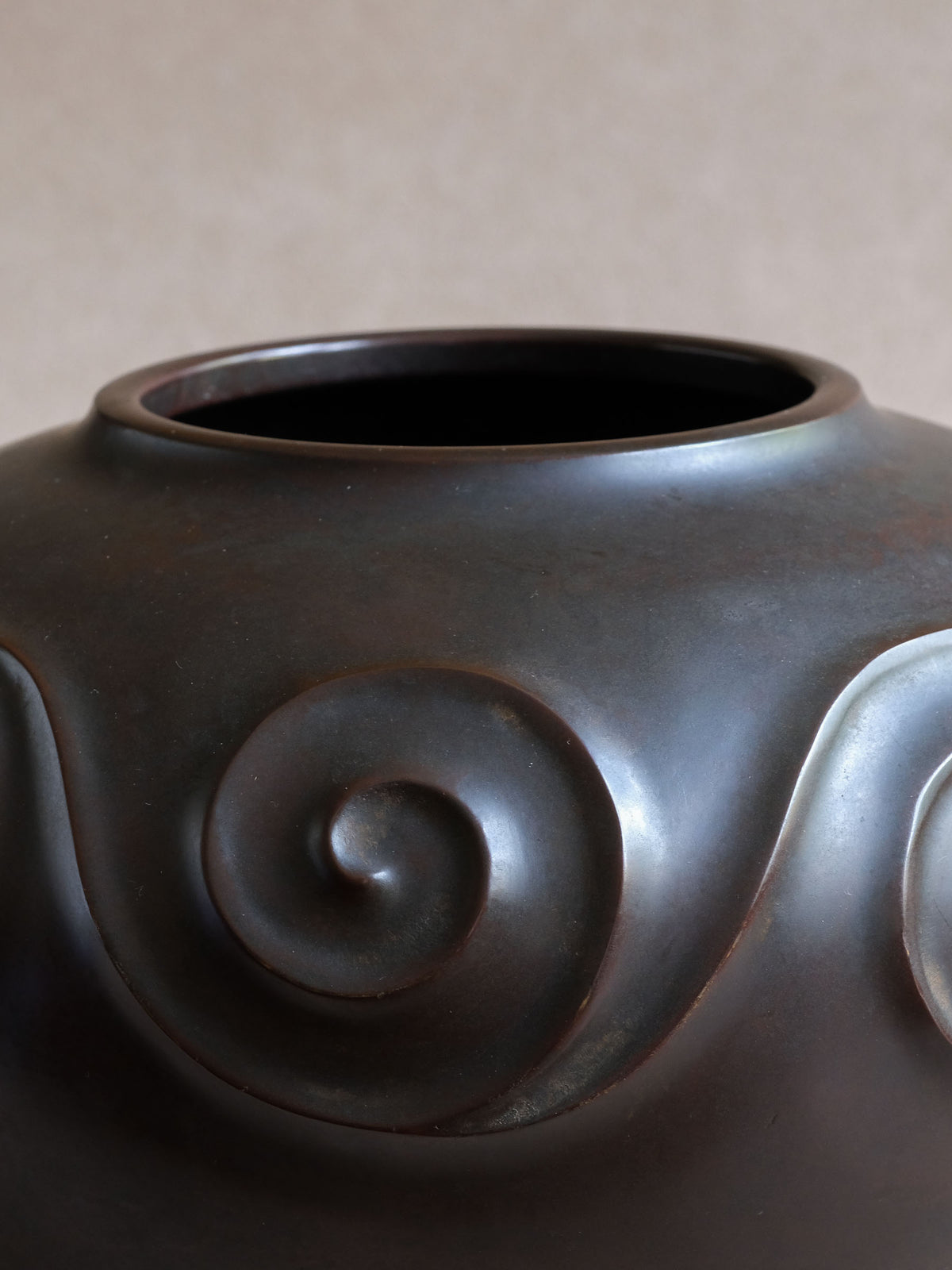 Close-up of wide mouth and raised spiral decoration on Yashima Boshū Japanese bronze vase.
